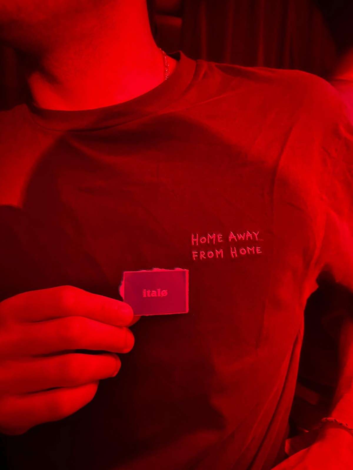 A red italø t-shirt printed with "Home away from home"