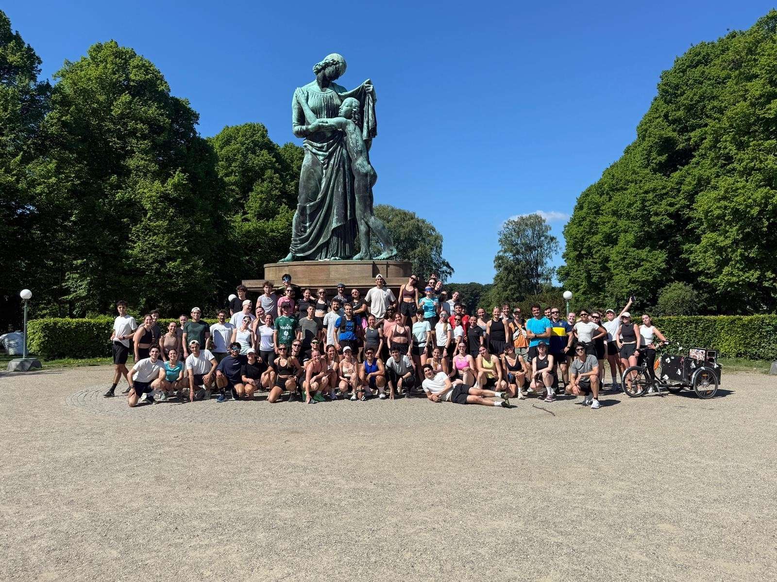 A large italø group photo in a Copenhagen park in front of a statue